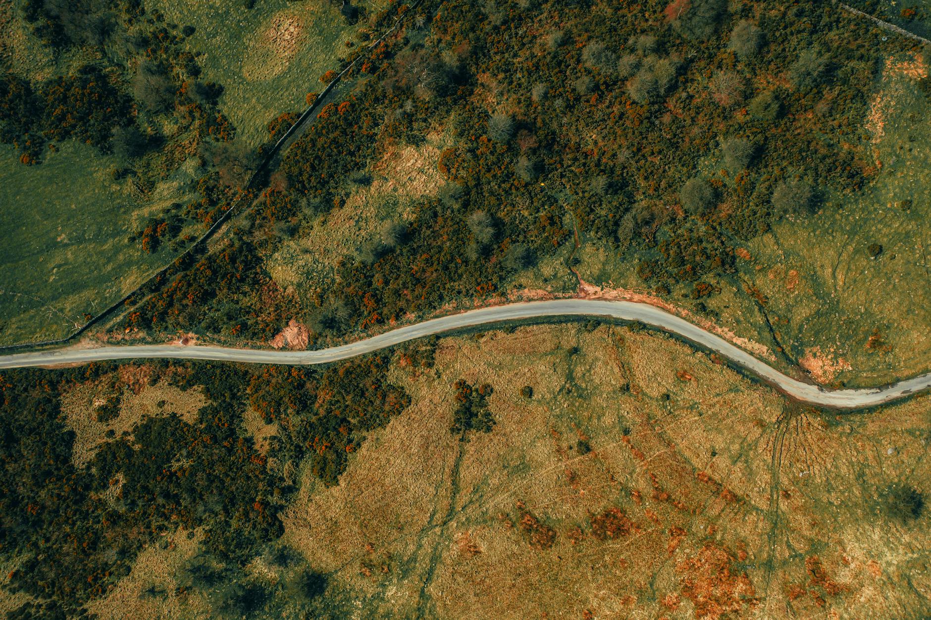 an aerial photo of a landscape with a windy road running through it